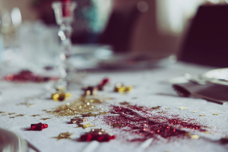 Messy Christmas table with discarded decorations, representing the waste left behind after the festive season.